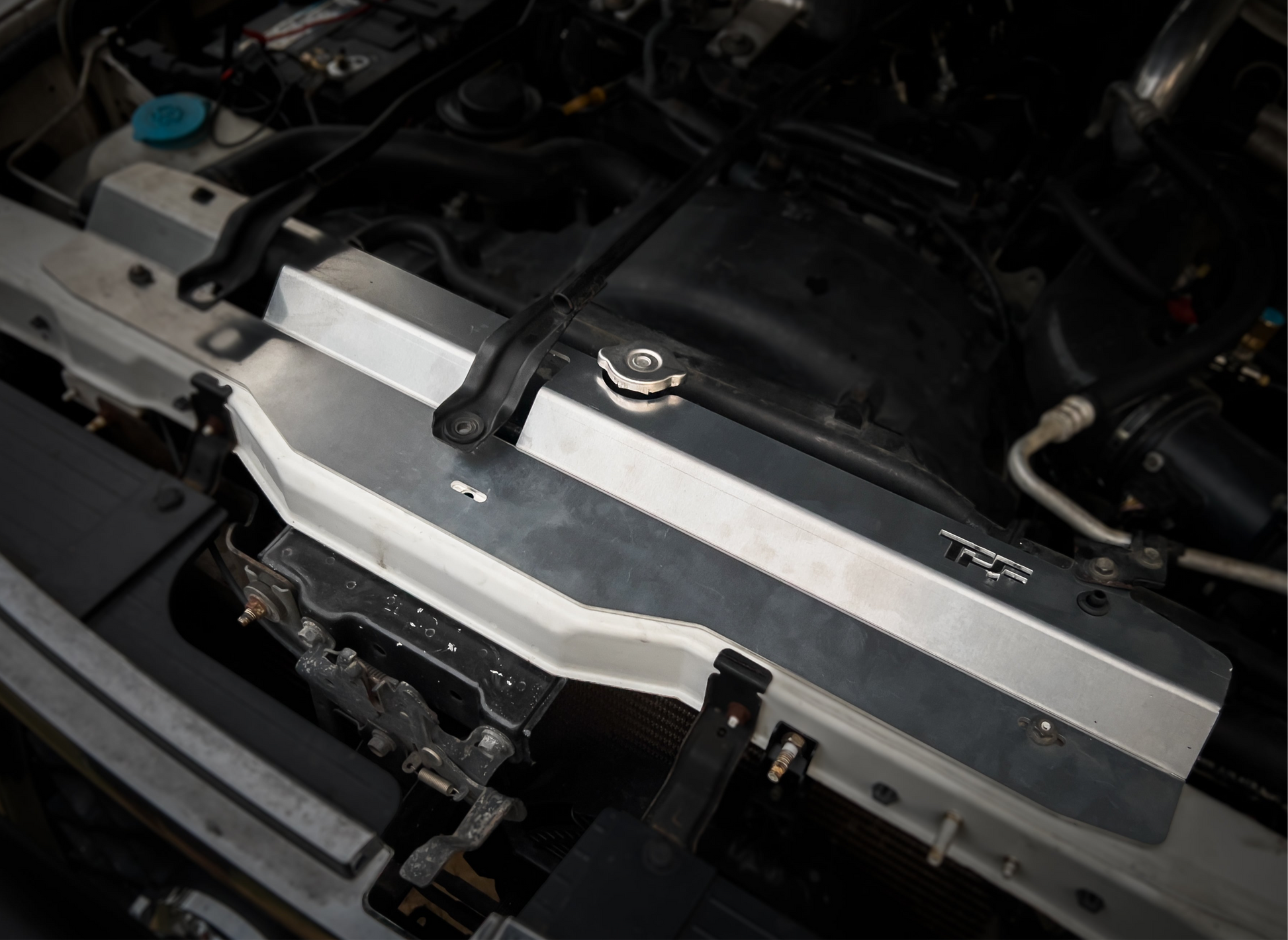 GU Patrol - silver aluminum radiator cover installed on a vehicle's engine bay.